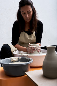 Woman making pottery in her studio.