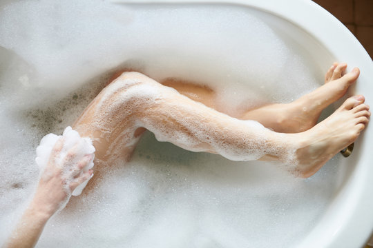 Overhead view of legs of woman having bubble bath