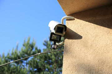 Kamera monitoringu z reflektorem led i czujnikiem ruchu na ścianie budynku. - obrazy, fototapety, plakaty