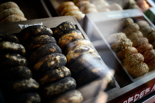 Poppy seed bagels stacked in a display case
