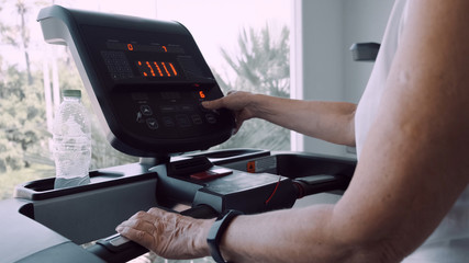 senior woman doing gymnastics on the treadmill, close up.