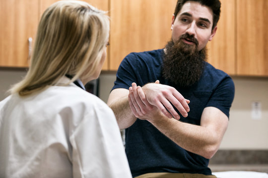 Clinic: Doctor Examines Man's Wrist Injury
