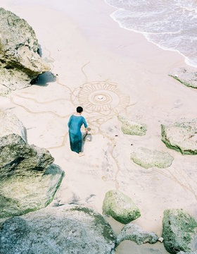 Asian woman drawing a mandala pattern on a beautiful rocky beach ,during a comfortable journey. shot by 120 films