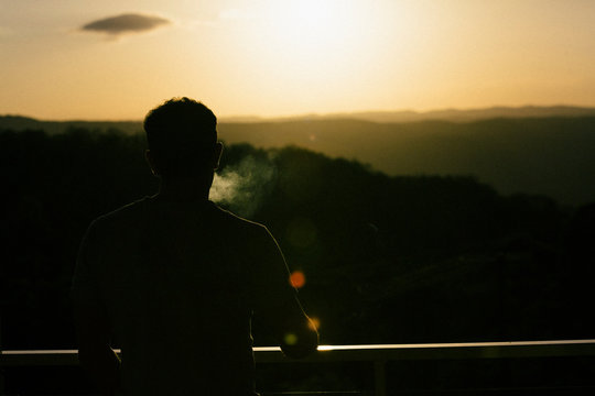 Man smoking watching the sun set