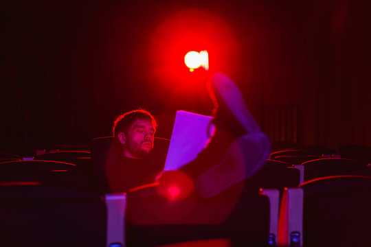 Actor reviewing script sitting in theatre.