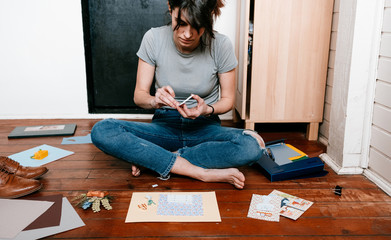 woman enjoying her free time at home doing paper handcrafts