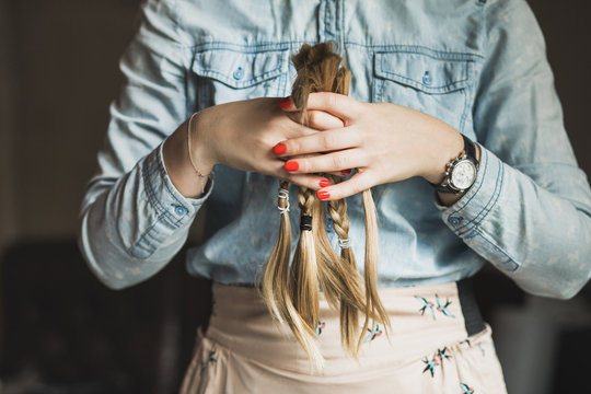 Young blond woman holding her cut hair preparing to donate them