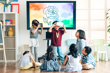 Preshool kids wearing virtual reality headset in classroom