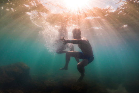 Couple glows in sun streaking into underwater world