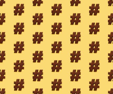Repetitive pattern of a chocolate hashtag on a golden background.