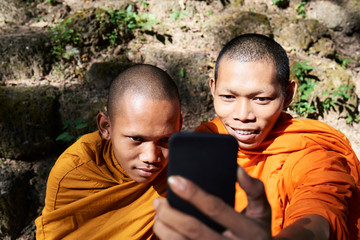 Two monks with cell phone.