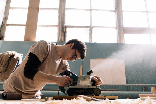 Carpenter polishing wood in shop