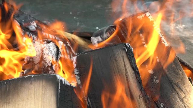 Closeup of firewood burning slowly with orange fire flame. Slow motion shot