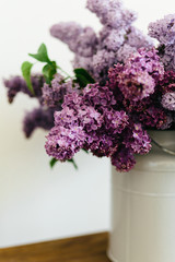 Awesome purple bouquet of lilac flowers in a stylish vase on a white background