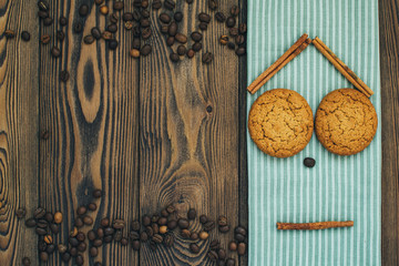 Funny face of gingerbread man, oatmeal cookies, sticks of cinnamon, textile, and roasted coffee beans