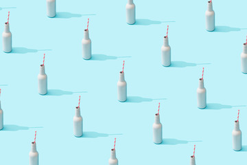 Trendy sunlight Summer pattern made with white bottle  on bright light blue background. Minimal summer concept.