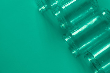 4 green glass jars on a green background with room for text