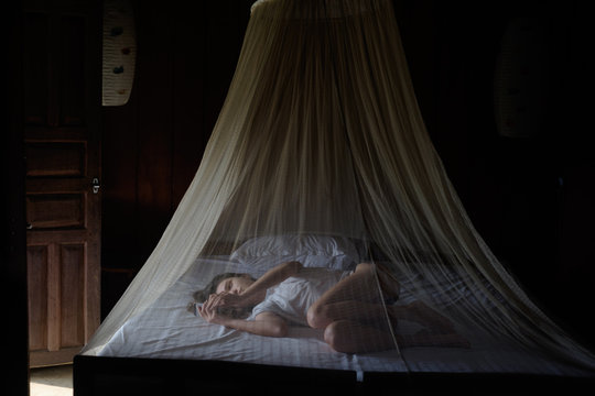 Young woman using smartphone on bed at home