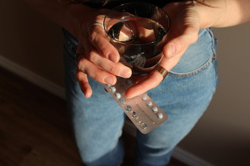 Young anonymous woman holding birth control pills