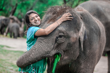 Girl having fun with elephants at Patara Elephant Farm, Chiang Mai, Thailand