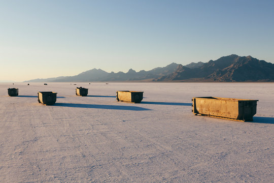 Large trash and recycling containers on playa at dusk, Bonneville Salt Flats, Utah