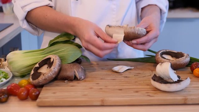 Chef peeling big mushroom