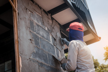 Construction workers plastering building wall using cement plaster