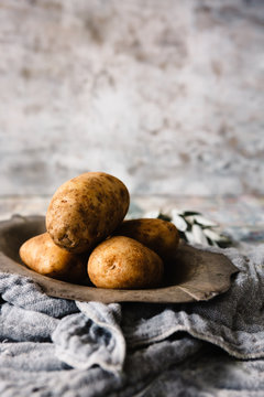 Unwashed potatoes on a vintage platter
