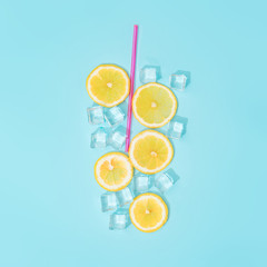 Fototapeta na wymiar Creative summer background composition with lemon slices, straw and ice cubes. Minimal top down lemonade drink concept.