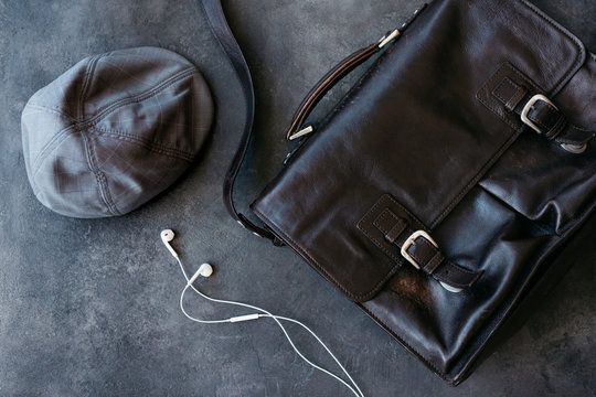 Brown leather satchel and a grey duckbill hat