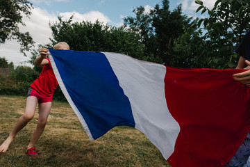 little boys running with a French flag before world cup soccer / football game.