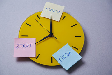 Time management deadline and schedule concept: yellow clock covered with stickers
