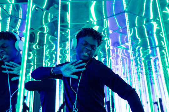 Expressive black man dancing in neon lights