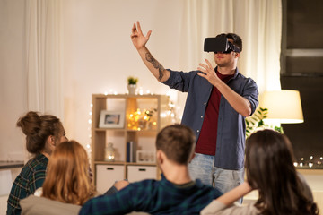 technology and entertainment concept - man with virtual reality headset or vr glasses playing videogame at home and
