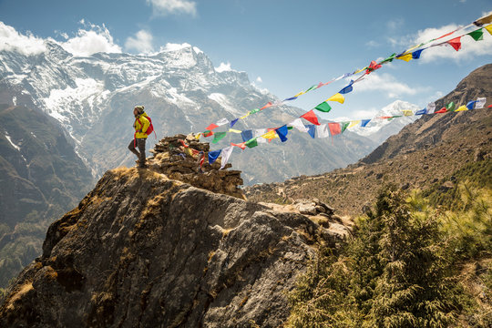 Female Hiker on Outcropping with Prayer Flags