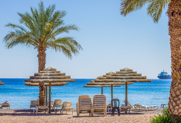 morning sand beach paradise scenery landscape colorful photography with umbrellas lounge and palm trees with view on a Red sea, beautiful destination for summer vacation   