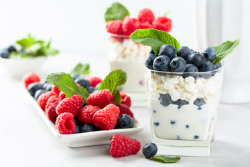 Cottage cheese with cream, raspberry and blueberry garnished with fresh mint.