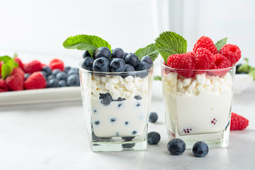 Cottage cheese with cream, raspberry and blueberry garnished with fresh mint.