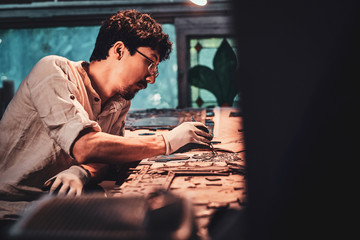 Expirienced restorer is choosing right peace of stained glass for his project.