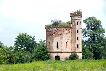 Fototapeta na wymiar Small ruined abandoned castle overgrown in vegetation