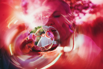 Woman blowing bubbles through light filter