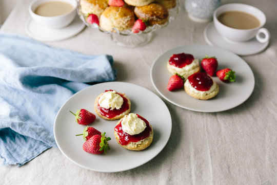 Cornish and Devonshire style scones with jam and cream opposite