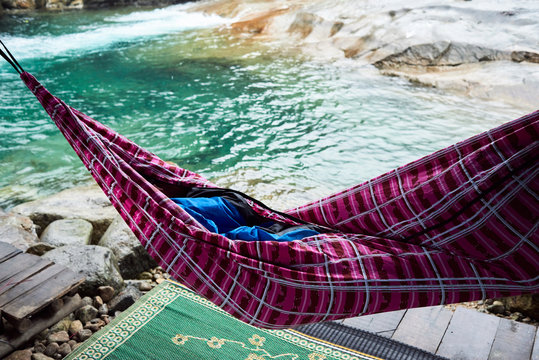 Hidden person inside of sleeping bag in paradise.