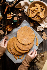 Overhead shot of homemade baked layers of Russian traditional honey cake on baking paper on wooden...