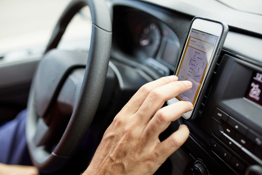 Man using application on his mobile phone in car.