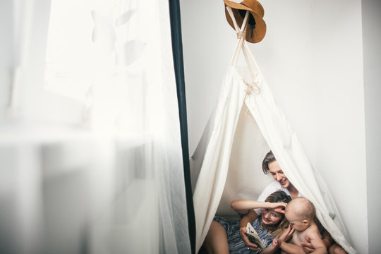 Young family reading a book in a hut