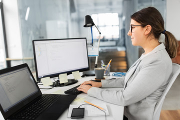 business, technology and people concept - businesswoman with computer working at office