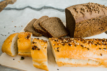 fresh sliced bread on a wooden board on a grey cloth