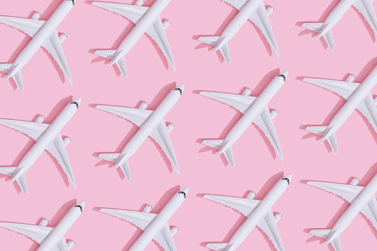 Creative composition made with passenger plane on pastel pink background. Summer travel or vacation pattern.