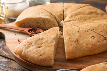 Composition with flatbread and kitchen accessories on wooden background, closeup and space for tex